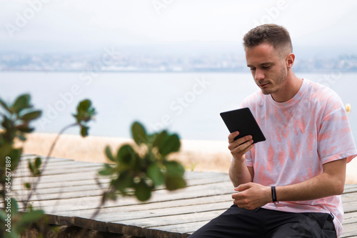 young man with digital tablet outdoors
