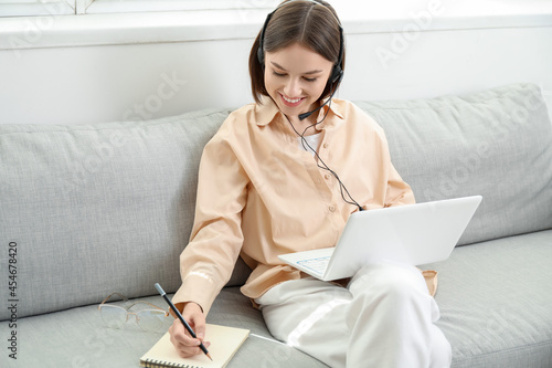 Young woman with laptop wri...