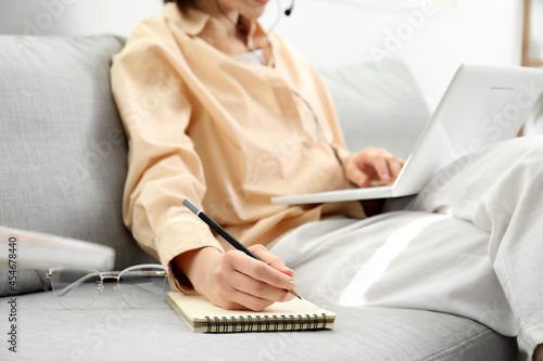 Young woman with laptop wri...
