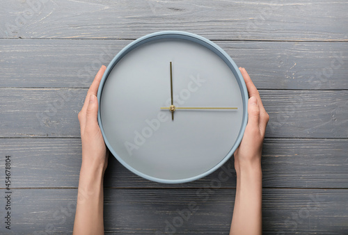 Female hands and clock on g...