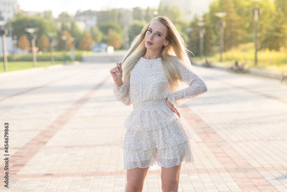 Portrait of a stylish and attractive Caucasian blonde girl posing in the summer on the street. Fashion concept. Portrait of a stylish and attractive Caucasian blonde girl posing in the summer on the street. Fashion concept.