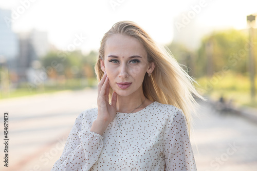 Portrait of a stylish and attractive Caucasian blonde girl posing in the summer on the street. Fashion concept.