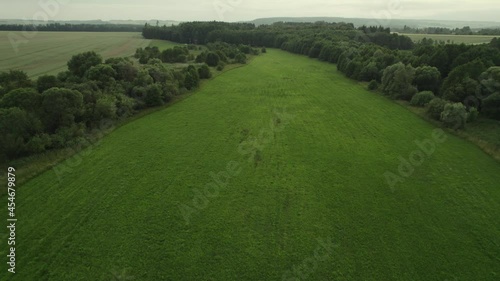 Aerial view of a large beautiful field.View of meadows, clouds over green meadows. Stunning aerial shot over lush green fields and meadows in the countryside, Shadows from clouds on green fields. photo