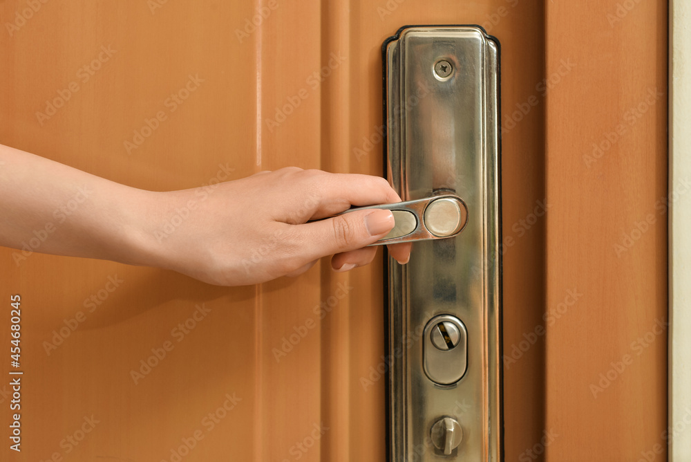 Obraz premium Woman opening door in room, closeup