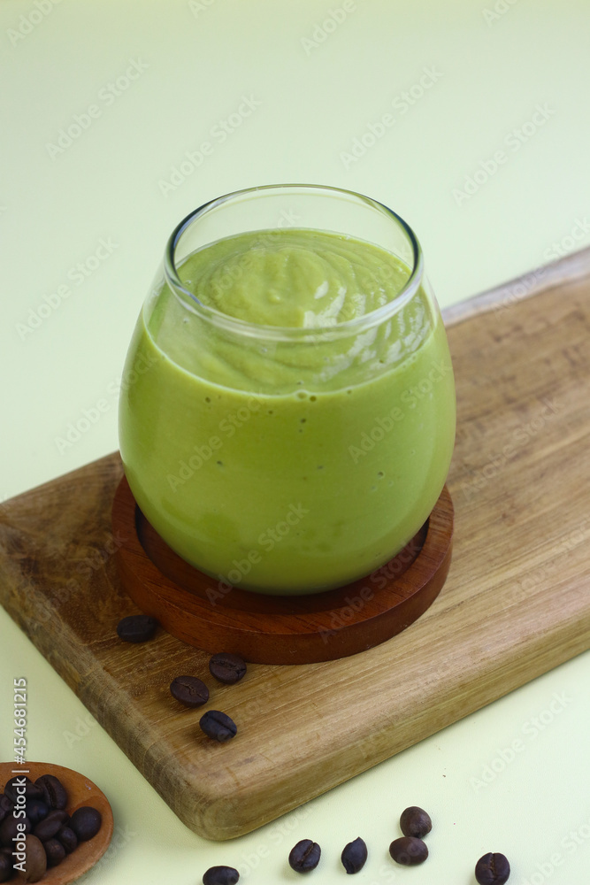Avocado Coffee smoothie on clear glass on isolated background, with avocado fruits and coffee beans. Avocado Coffee smoothie on clear glass on isolated background, with avocado fruits and coffee beans.