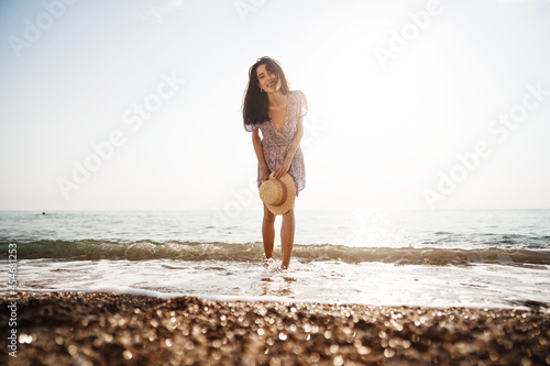 Portrait of young woman walking on the beach on sunrise