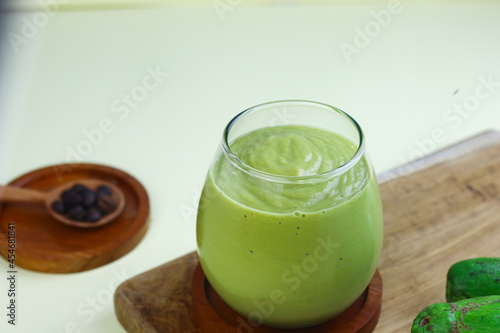 Avocado Coffee smoothie on clear glass on isolated background, with avocado fruits and coffee beans. 