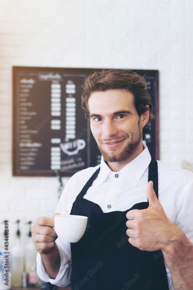 portrait handsome man of barista barista uniform holding coffee cup cappuccino on hand at counter in coffee shop foto de Stock | Adobe Stock