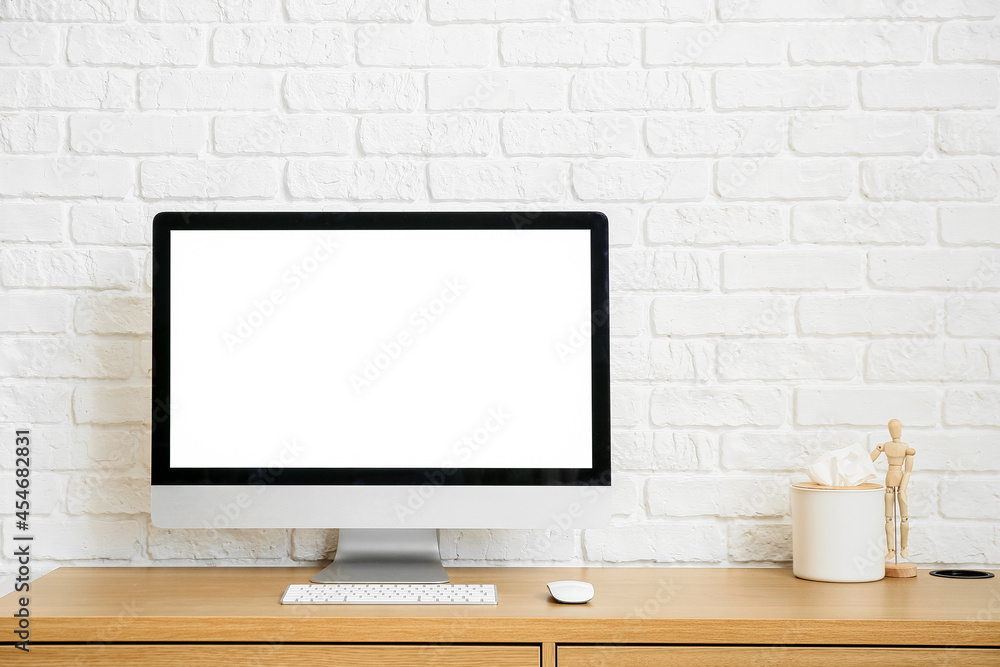 Fototapeta premium Modern workplace with computer near brick wall