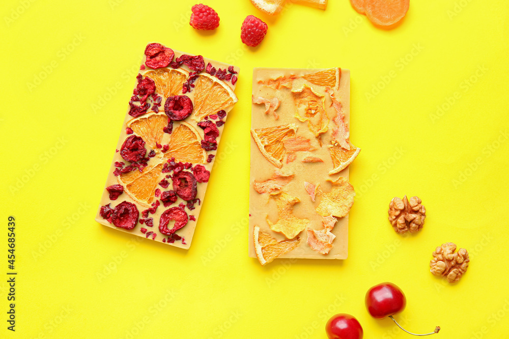 Handmade chocolate bars with fruits, berries and nuts on color background Handmade chocolate bars with fruits, berries and nuts on color background