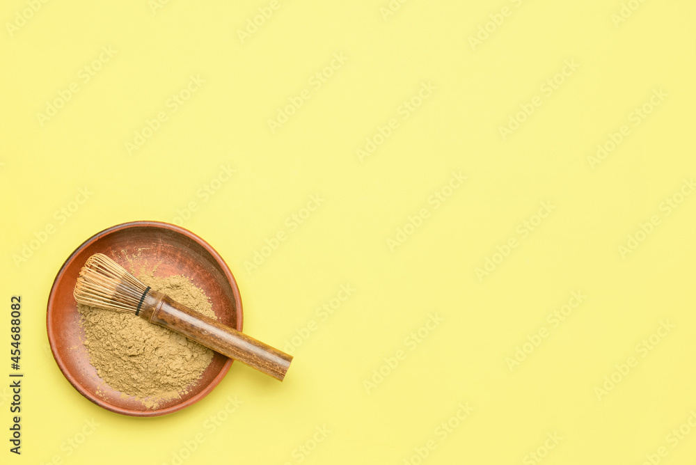 Bowl with powdered matcha tea and chasen on color background Bowl with powdered matcha tea and chasen on color background