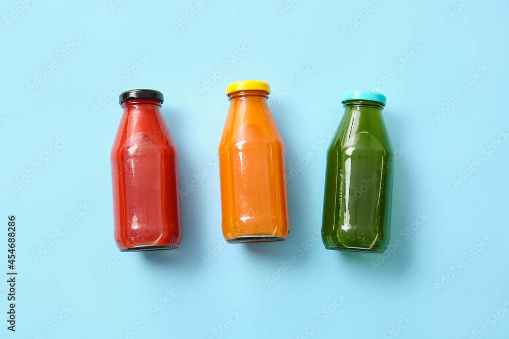 Bottles with healthy juice on color background Bottles with healthy juice on color background