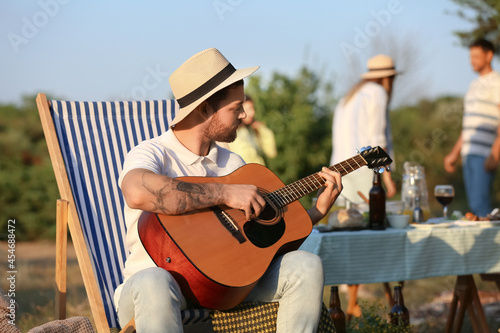 Young man playing guitar at...