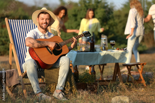 Young man playing guitar at...