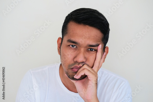 Close up portrait of Asian man face doing boring expression