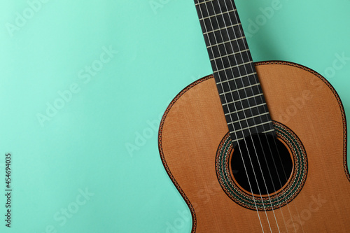 Classical guitar on mint background, space for text