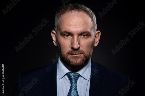 Man in a business suit on a black background © roman1relax