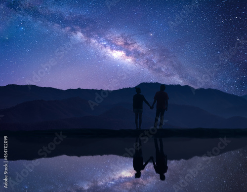 Silhouette of young couple traveler standing with beautiful night sky with stars and milky way. Landscape Milky Way , Lovers, Couple, Relationship.