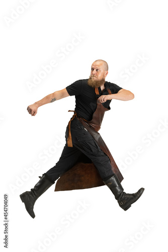 Portrait of strong bearded bald man, blacksmith wearing leather apron or uniform isolated on white studio background. Concept of labor, retro professions, power, beauty, humor
