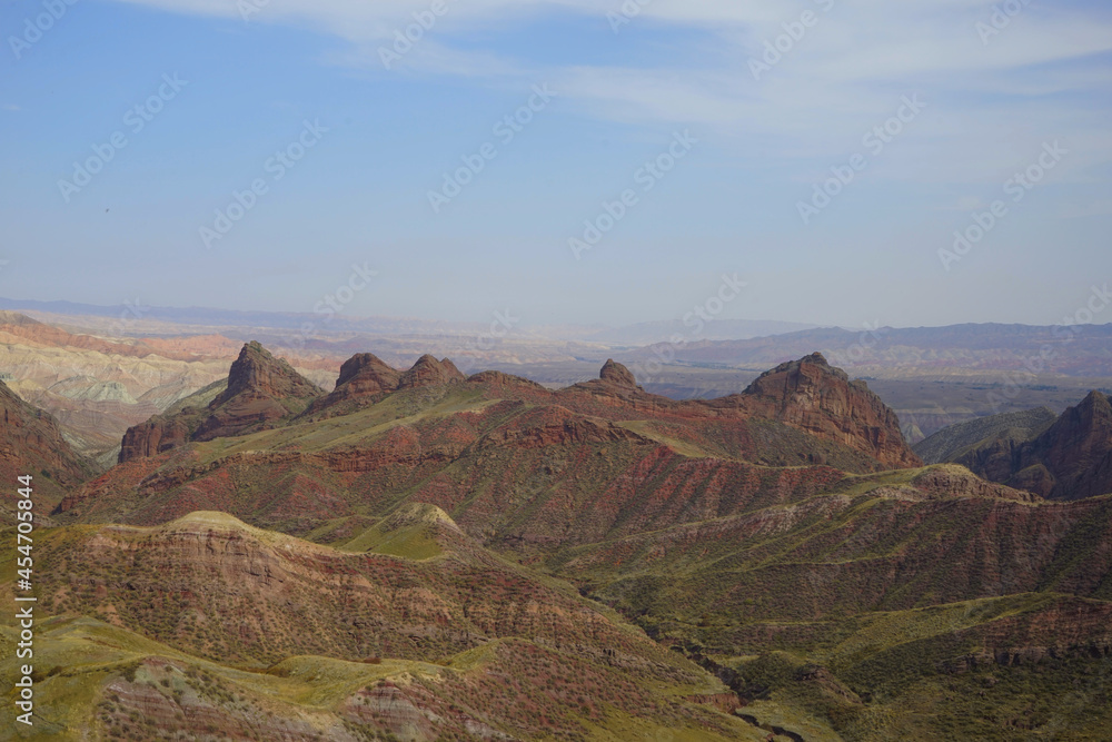 Hills formed by erosion of colored rocks with reddish-yellow and orange stripes.