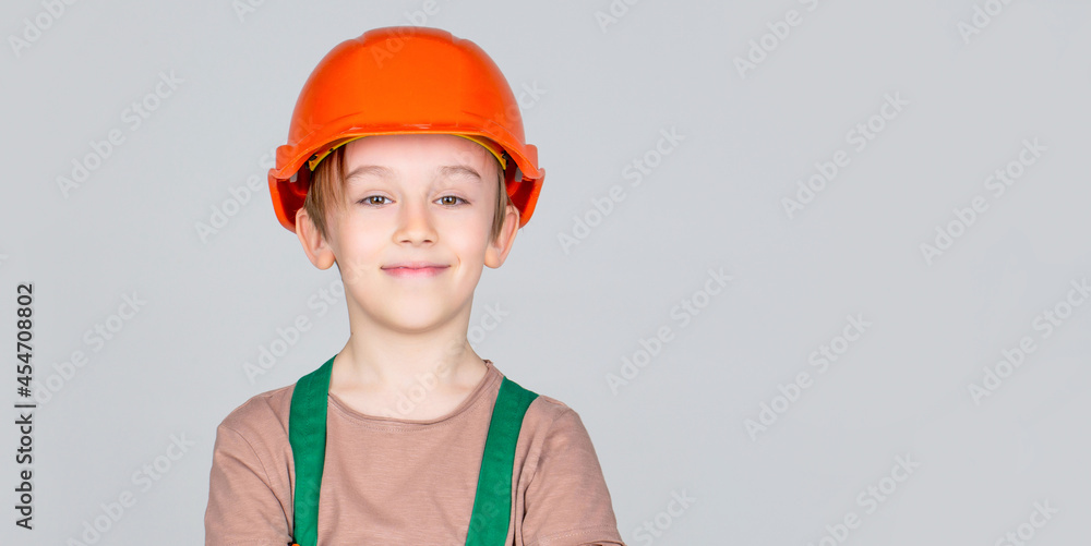 Child dressed as a workman builder. Little boy wearing helmet. Portrait little builder in hardhats. Child building helmet, hard hat. Little builder in helmet Child dressed as a workman builder. Little boy wearing helmet. Portrait little builder in hardhats. Child building helmet, hard hat. Little builder in helmet