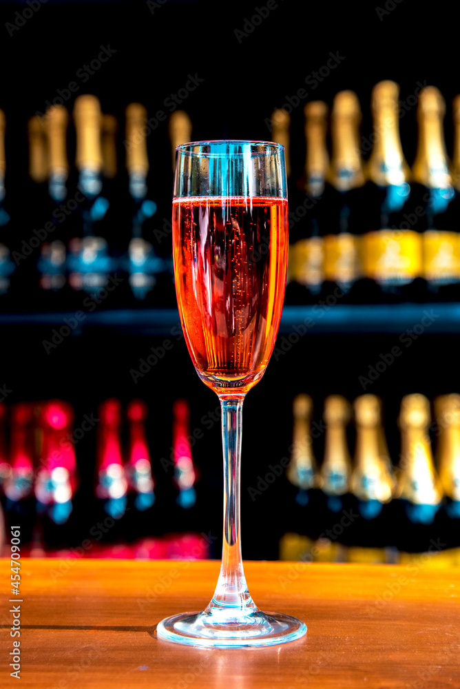 Abstract image of a glass with champagne on the background of bottles (celebrations, anniversaries, wine - concept)