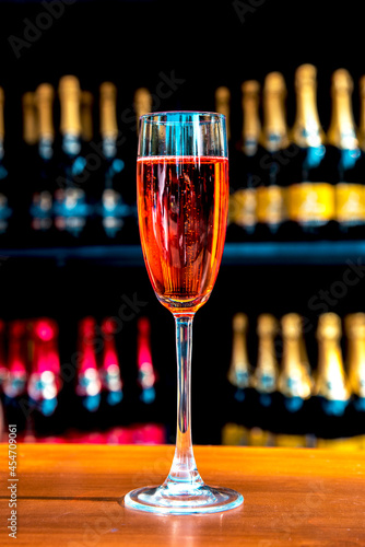 Obraz na płótnie Abstract image of a glass with champagne on the background of bottles (celebrations, anniversaries, wine - concept) w salonie