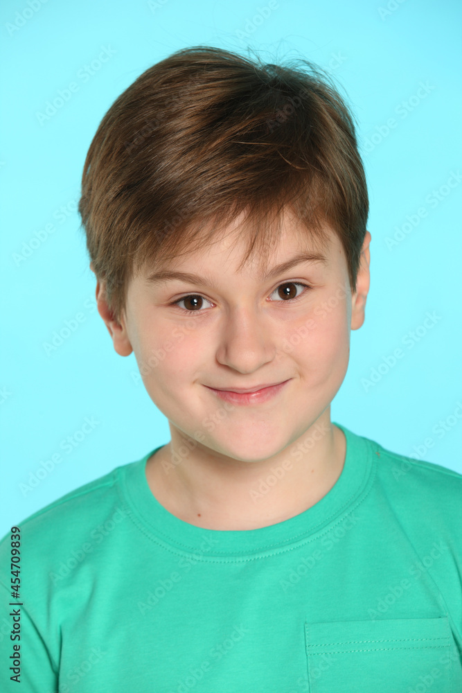 In this portrait of a teenager, a handsome, cheerful young boy looks eye to eye and smiles slightly. In this portrait of a teenager, a handsome, cheerful young boy looks eye to eye and smiles slightly.