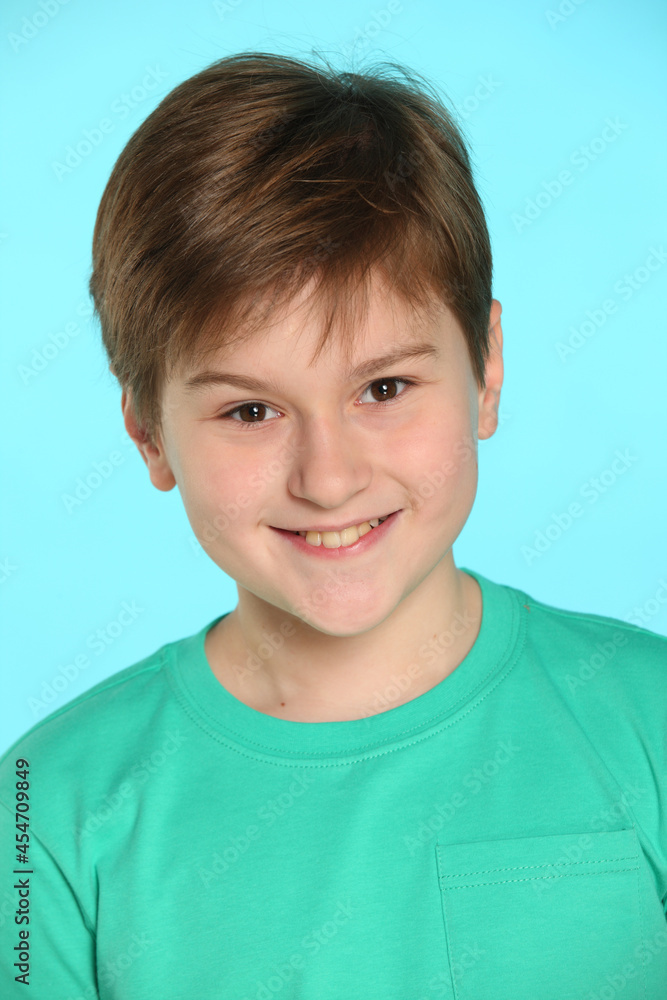In this portrait of a teenager, a handsome, cheerful young boy looks eye to eye and smiles playfully. In this portrait of a teenager, a handsome, cheerful young boy looks eye to eye and smiles playfully.