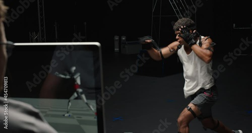 man wearing motion capture suit in studio performing martial arts actor boxing wearing mo-cap suit for 3d character computer game animation for virtual reality fighting gaming