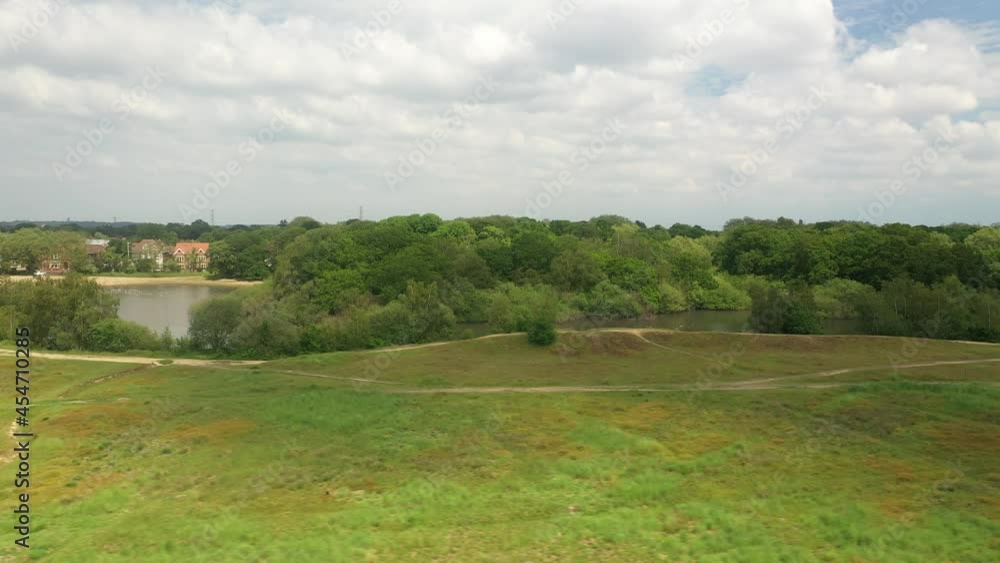 Meadows with pathways and pond surrounded with trees and shrubs Meadows with pathways and pond surrounded with trees and shrubs