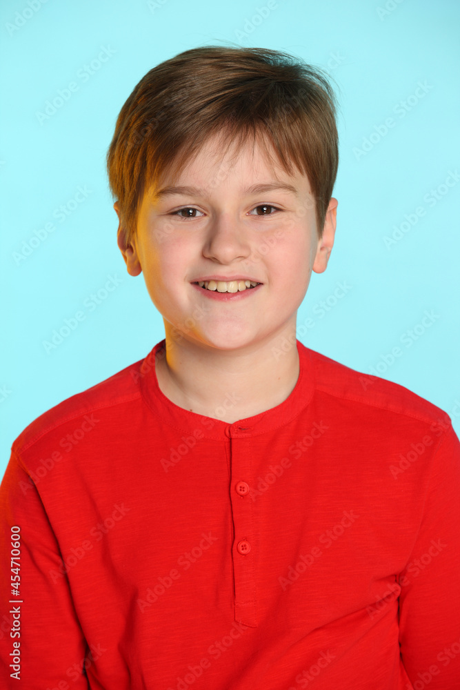 Close-up portrait: trendy, cheerful teenage boy in a red sweater. He smiles broadly and looks eye to eye. Close-up portrait: trendy, cheerful teenage boy in a red sweater. He smiles broadly and looks eye to eye.