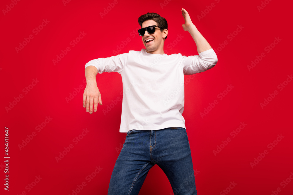 Photo of funny brunet young guy dance wear white shirt spectacles isolated on red color background Photo of funny brunet young guy dance wear white shirt spectacles isolated on red color background