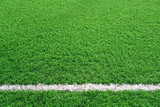 Artificial grass of football field with white stripe, Soccer corner line detail, Green astro turf for texture background, Perspective