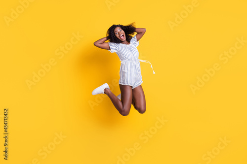 Full length body size view of pretty ecstatic cheerful ecstatic thin girl jumping having fun rejoicing isolated over bright yellow color background