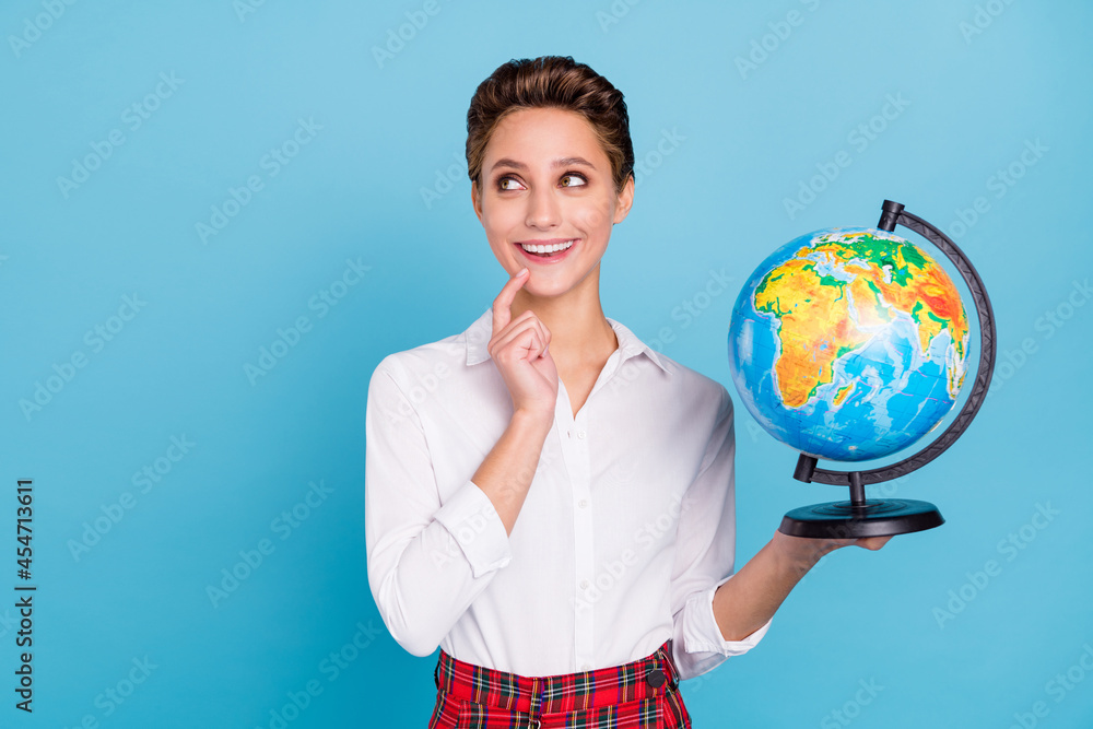Fototapeta premium Photo of smart blond millennial lady hold globe look empty space wear shirt isolated on blue color background