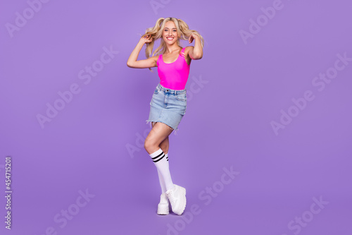 Full length body size view of attractive cheery girl posing making hairdo isolated over bright purple violet color background