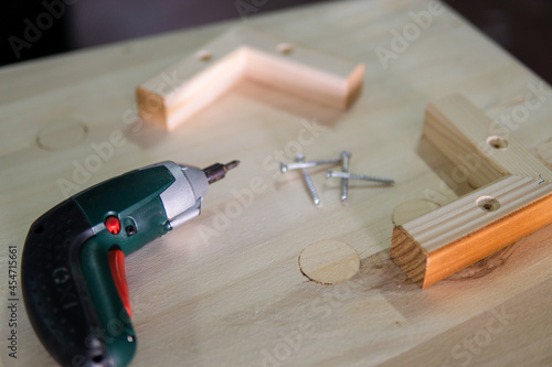 Wallpaper Mural Electric screwdriver and several screws on top of a wooden table for a carpentry work Torontodigital.ca