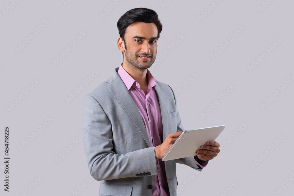 An employee in formal business suit holding a digital tablet,looking at the camera. An employee in formal business suit holding a digital tablet,looking at the camera.