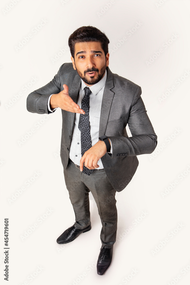 Portrait of a man in formal business suit standing looking upwards pointing at his watch. Portrait of a man in formal business suit standing looking upwards pointing at his watch.