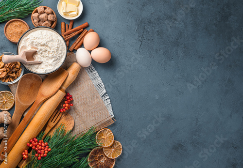 Christmas, culinary background with ingredients and kitchen tools for baking on a gray-blue background. Top view, copy space.