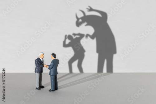 Business partner monster. Businessmen shake hands but the shadow indicates that one monster