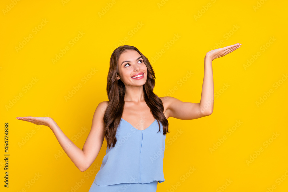 Photo of young woman happy positive smile measure pros cons alternative choice advertise isolated over yellow color background Photo of young woman happy positive smile measure pros cons alternative choice advertise isolated over yellow color background