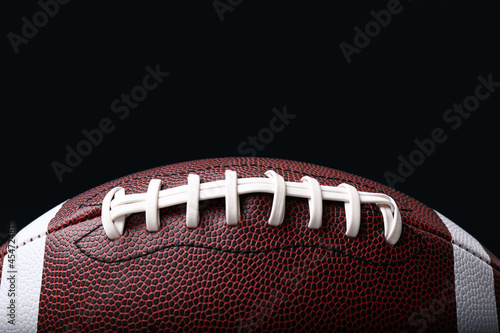 Leather American football ball on black background, closeup © New Africa