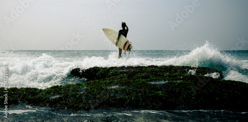 Woman surfer with surfboard going to surf at seaside