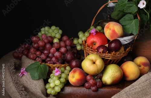 Fototapeta Naklejka Na Ścianę i Meble -  Still life in retro style with grapes, peaches, pears and apples on a dark background