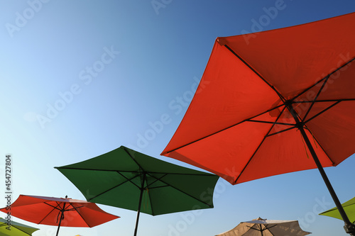 Colorful beach umbrellas against blue sky on sunny day