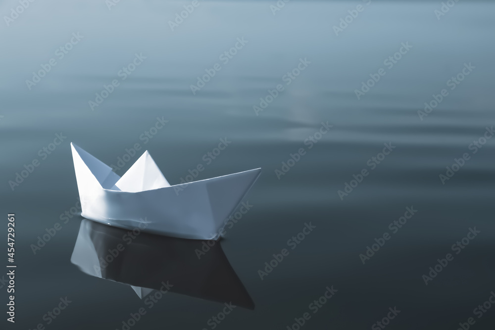White paper boat floating on river, space for text White paper boat floating on river, space for text