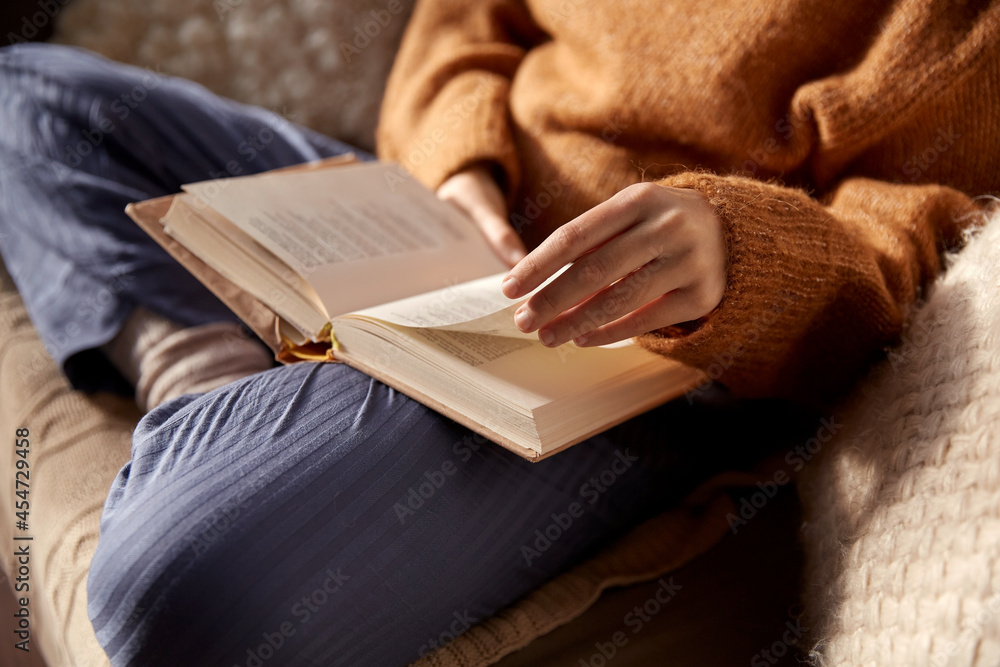 people, season and leisure concept - close up of woman in warm sweater reading book at home - obrazy, fototapety, plakaty 