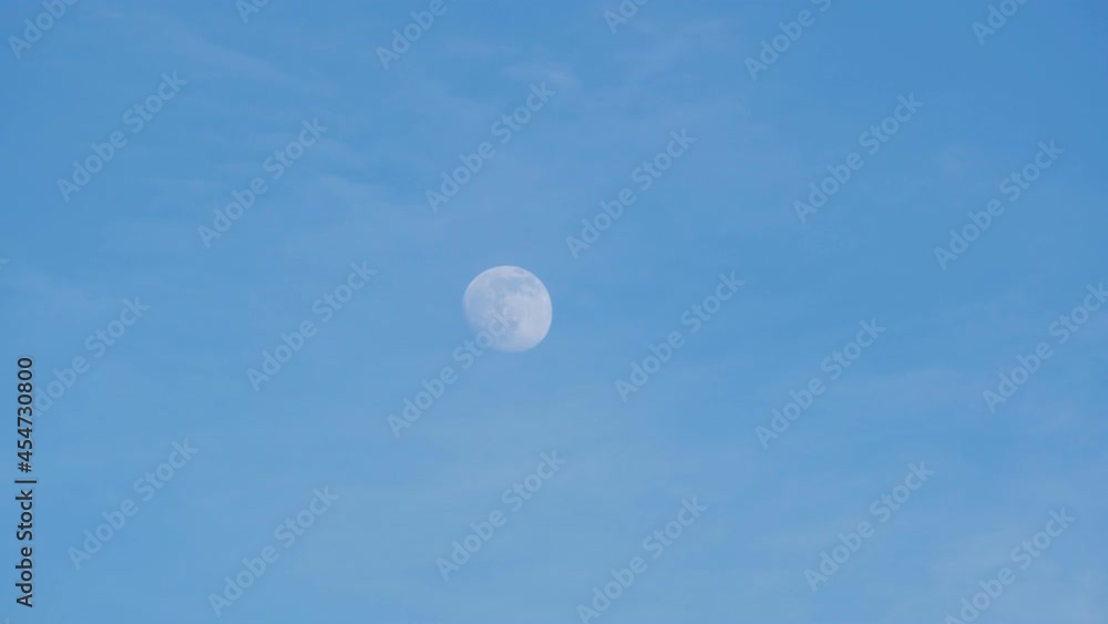The moon on the background of the blue sky on a bright sunny day, in winter The moon on the background of the blue sky on a bright sunny day, in winter